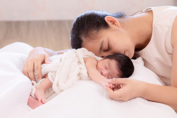 Selective Focus, Asian mother tired sleep with adorable newborn feeding, mom exhausted sleep with baby girl hold hand together for trust, protection, motherhood lifestyle take care infant at home
