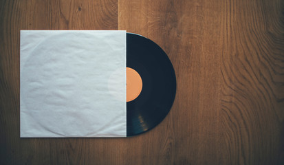 LP record record with sleeve on wooden background, copy space
