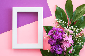 White frame and bouquet flowers on pink purple background. Greeting card Flat Lay Mockup Concept Hello summer, Mother's day, Womens day, Good day Template for text and design