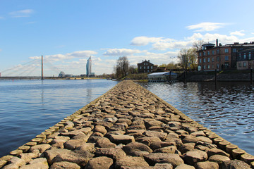 A rocky pier separates the harbor and quiet center district in the background.	