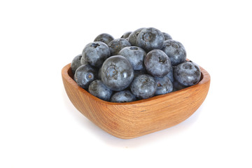 Tasty blueberries in a wooden bowl  isolated on white