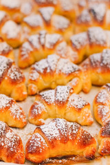 Croissants made in an artisanal way, freshly baked with its characteristic golden color, with powdered sugar on its surface, selective focus