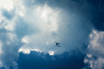Airplane flying in the deep blue sky among clouds