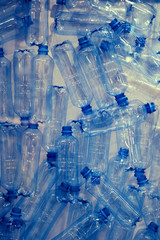 Empty plastic bottles with blue lids, close-up