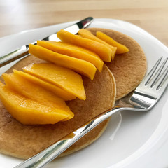 Homemade oat pancakes with sliced mango