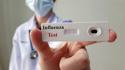 Doctor show positive rapid laboratory influenza test for diagnosis influenza virus infection or flu disease, ready for screening and treatment. Medical infectious test and investigation concept
