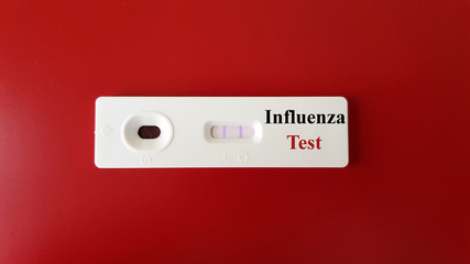 Positive Influenza test with sample of testing in rapid kit test for screening and diagnosis influenza virus infection (flu disease) on background. Medical and infectious investigation concept