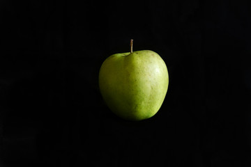Green apple on a black background.