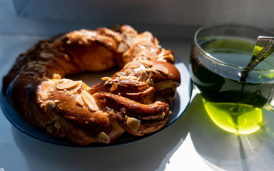bagel on a plate and a glass of tea are on the table