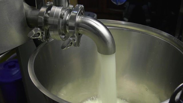Cheese whey is drained from a cheese cooker into a bucket. The equipment for the production of stainless steel cheese is technologically and hygienically.