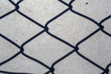 Wire fence shadow on floor
