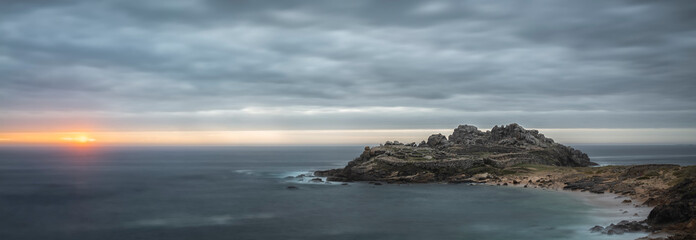 sunset over the sea and the Castro of Baroña ruins in Galicia in Spain