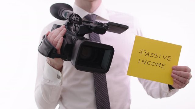 Passive income concept. Businessman with video camera earning second income.