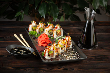 set of sushi rolls on a rectangular black plate