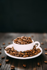 White cup and dish with coffee beans.