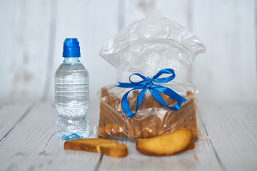 A bottle of water, crackers, drying on the background of boards for a healthy lifestyle.