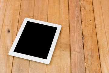 White tablet on brown wood table background