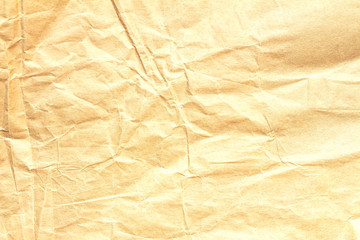 Close-up of crumpled light yellow craft paper with space for text.