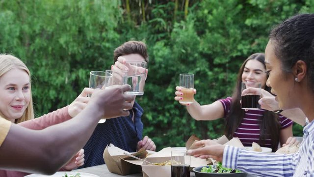 Multi-Cultural Friends Making Toast In Garden At Home Enjoying Summer Garden Party