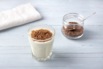 Simple healthy breakfast or snack. Natural yogurt with ground flax seeds in glasses on a light blue background