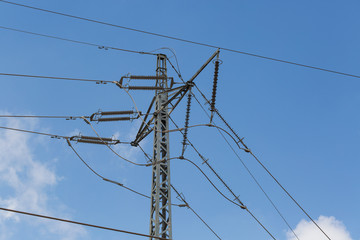 High-voltage support of a power line against the clear blue sky, electric wires. Energy and industry.