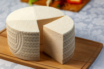 Cutting a large head of fresh homemade goat cheese.