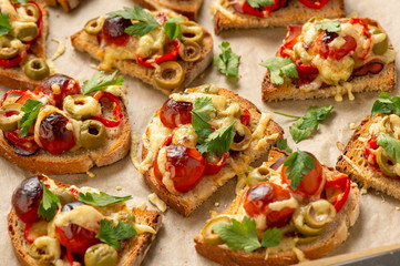 Hot crust toasts with ham, olives, tomatoes and cheese, breakfast idea.