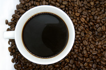 white coffee cup and roasted coffee beans that isolated on white background. top view.