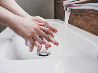 Woman wash hand under the water tap. hygiene virus prevention