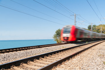 Fototapeta premium passenger train goes along the seashore in day