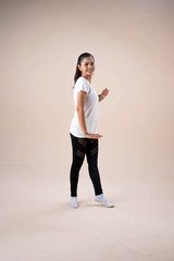 Fototapeta premium Young beautiful lady wearing sportwear,standing feet aparts kneel ,stepping,raise hands up and down little twisted,dance workout for exercise,with happy feeling
