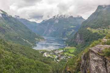 Naklejka na ściany i meble View to Geiranger fjord and eagle road surrounded by clouds from Dalsnibba mountain, serpentine road, Norway, selective focus. Village in Flam - Norway - nature and travel background