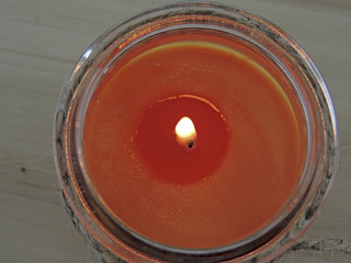 aromatic candle in a jar on a light background.