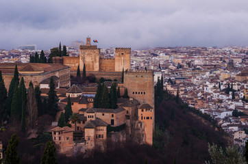Naklejka premium View of the Alhambra and the Generalife and the city of Granada from the viewpoint of the Silla del Moro at sunrise.