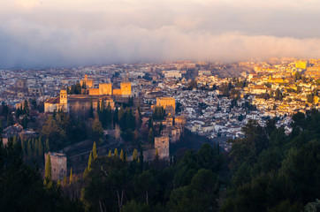Fototapeta na wymiar View of the Alhambra and the Generalife and the city of Granada from the viewpoint of the Silla del Moro at sunrise.