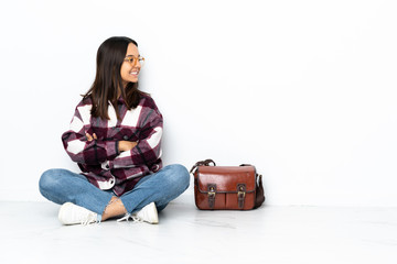 Young student woman sitting on the floor in lateral position