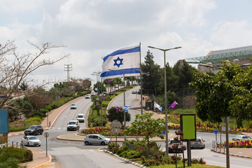 Fototapeta premium White and blue ribbons on sky background. Flags and decorations for the independence day in city Nof HaGalil.