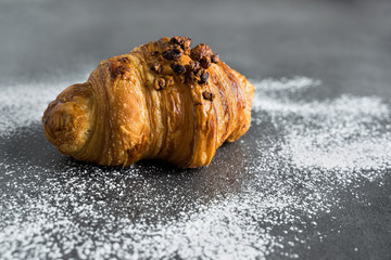 Photograph of a recently baked traditional croissant, a delicious snack.