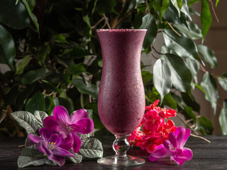Cocktail with fruits and berries in a tall glass on a dark background