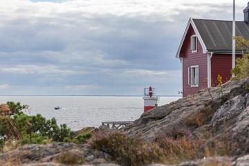 old lighthouse, house and boat entering the sea gate in the Baltic Sea, selective focus