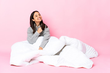 Young mixed race woman wearing pijama sitting on the floor proud and self-satisfied