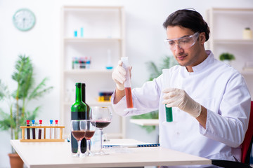 Male chemist examining wine samples at lab