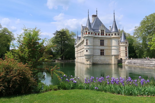 Châteaux de la Loire, château d'Azay-le-Rideau au bord de l’eau, vu du parc avec des fleurs (iris) au printemps (France)