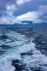 Storm clouds and raging waves in the sea in the evening during a storm in winter.