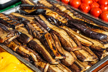 Grilled vegetables on the table. Fried vegetables in a metal stand at the fair.Cooking at the festival.