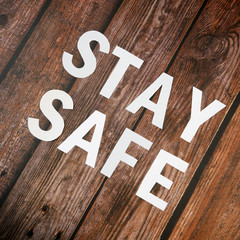 Stay home, stay safe slogan from white paper on wooden background, protection measure from...