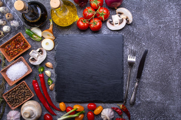 serving, slate stone for serving dishes surrounded by fresh vegetables, spices and ingredients for cooking