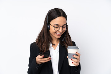Young telemarketer woman isolated on white background holding coffee to take away and a mobile