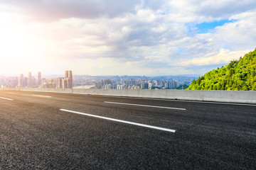 Fototapeta premium Empty asphalt road and Chongqing city skyline and buildings at sunset,China.