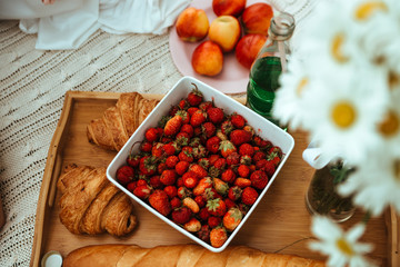 A plate of strawberry with croissants on a small table